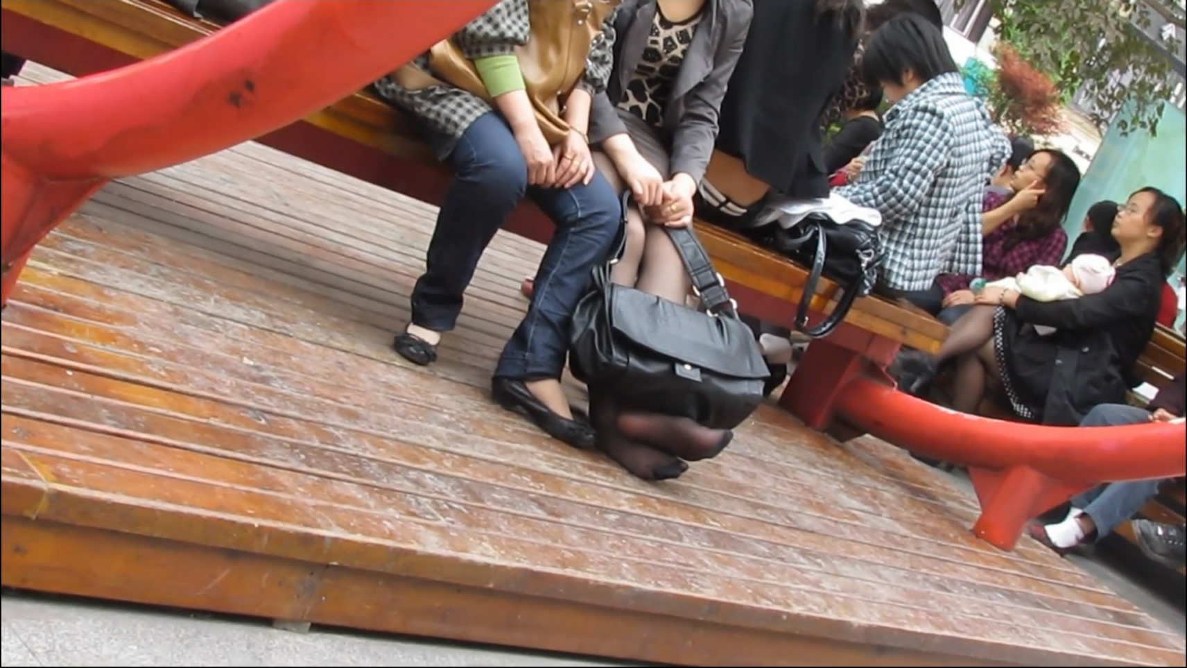 Legs dangling, black bag and black nylon feet